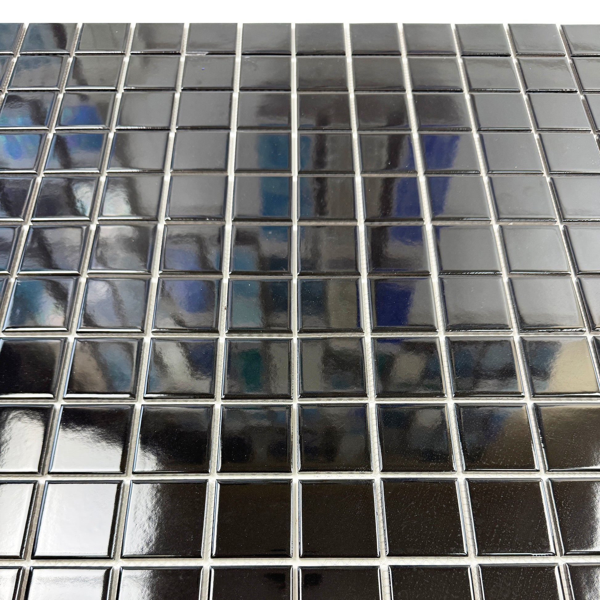 Close-up of a black mosaic tiles with reflections.