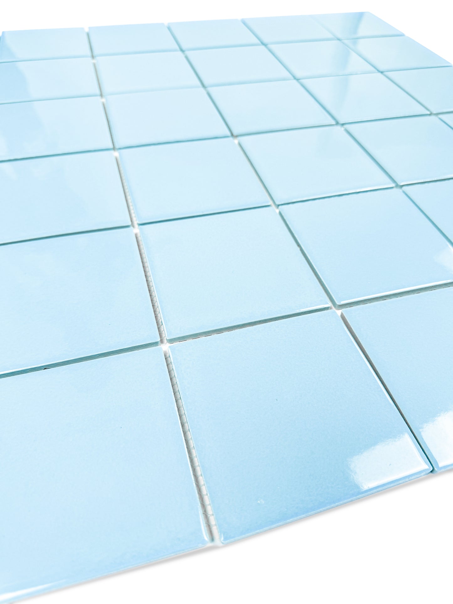 Close-up of blue square tiles with white grout on a white background