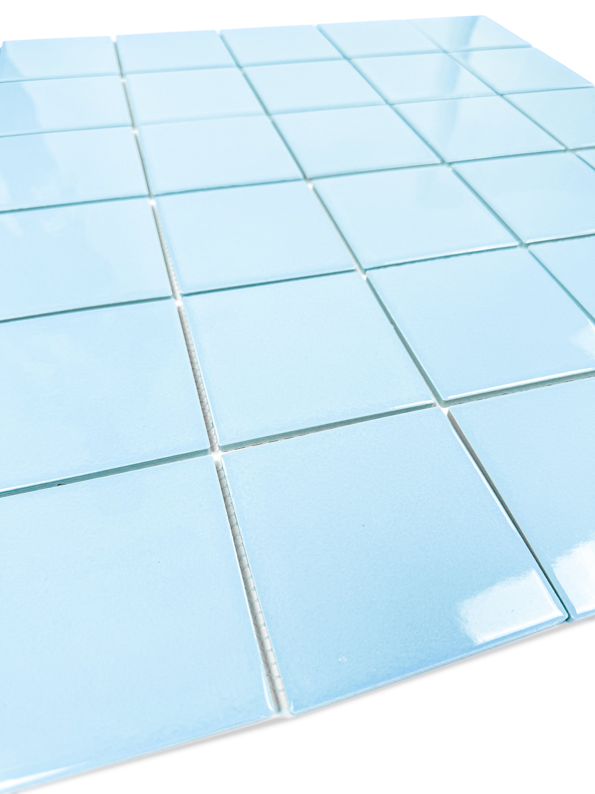 Close-up of blue square tiles with white grout on a white background