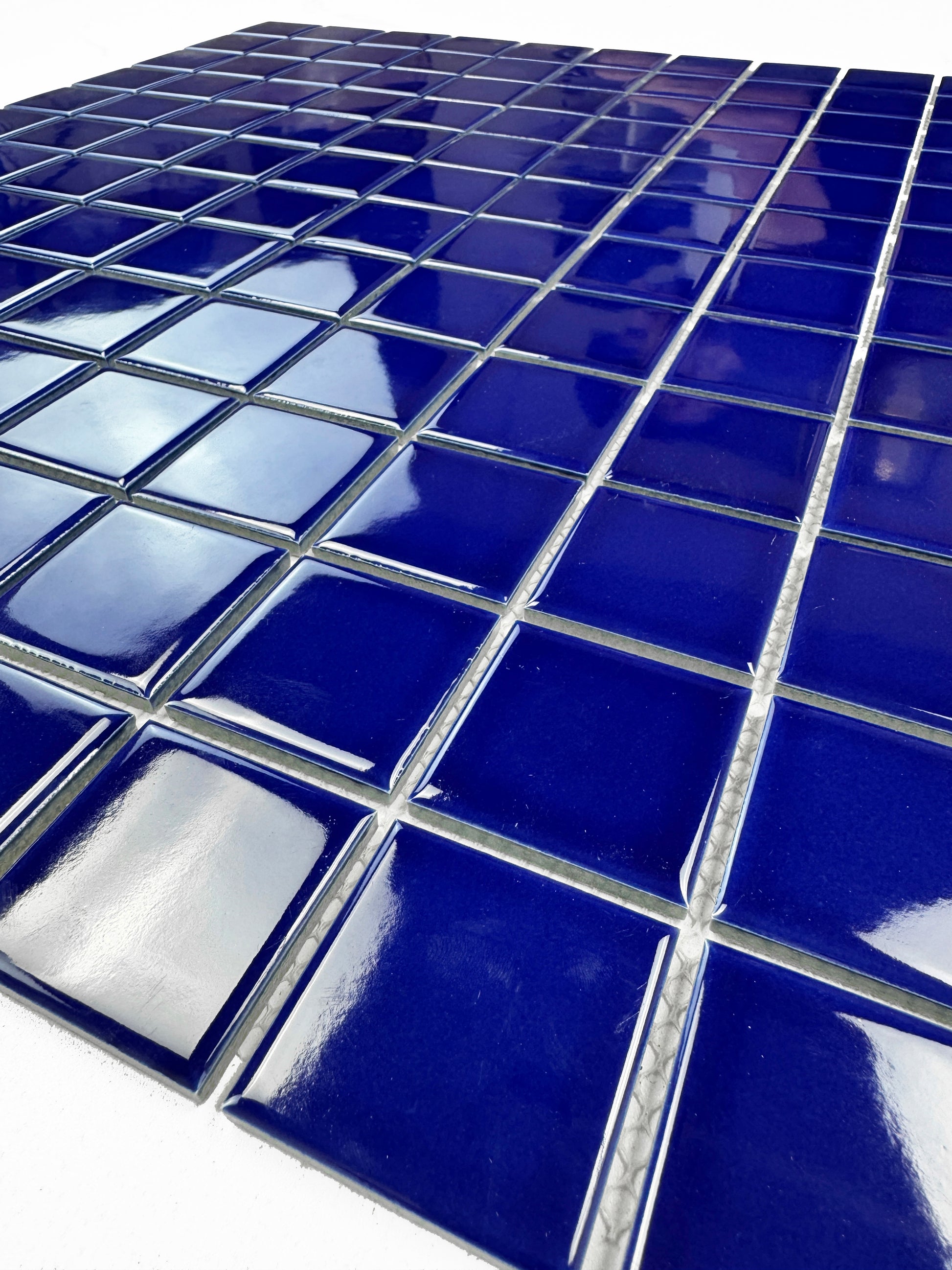 Close-up of blue porcelain tiles with grout line.