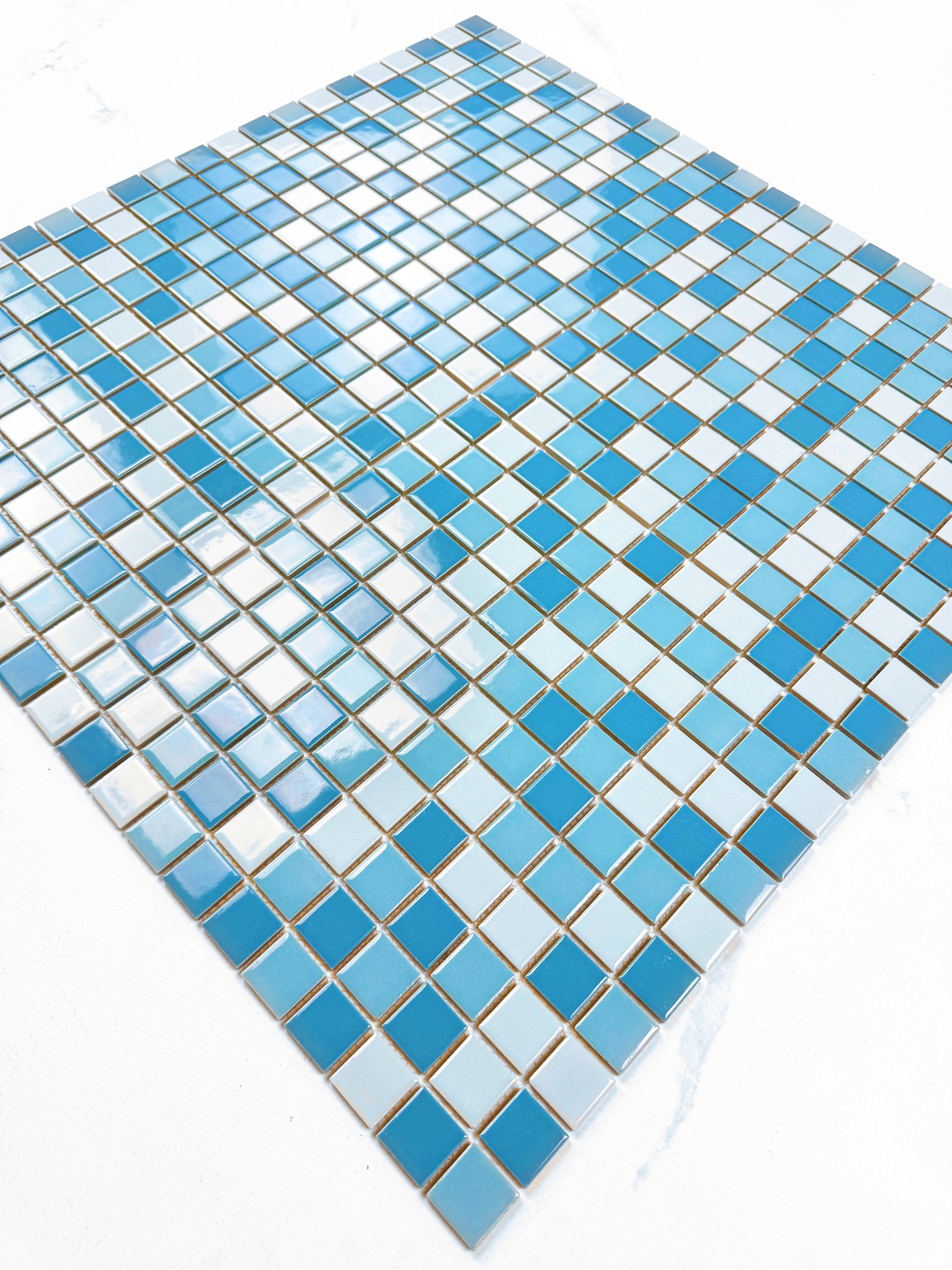 Mosaic tile pattern with blue and white squares on a white background