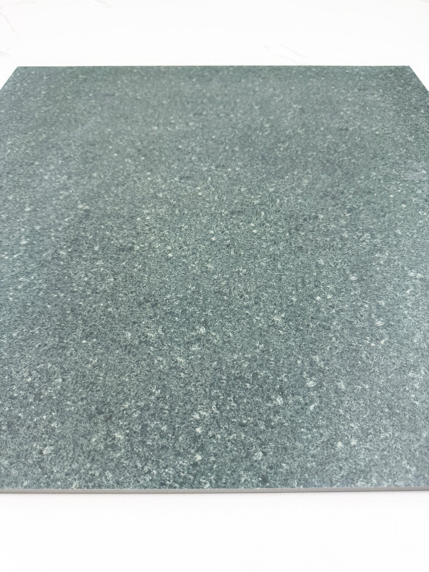 green sukabumi with a speckled pattern on a white background
