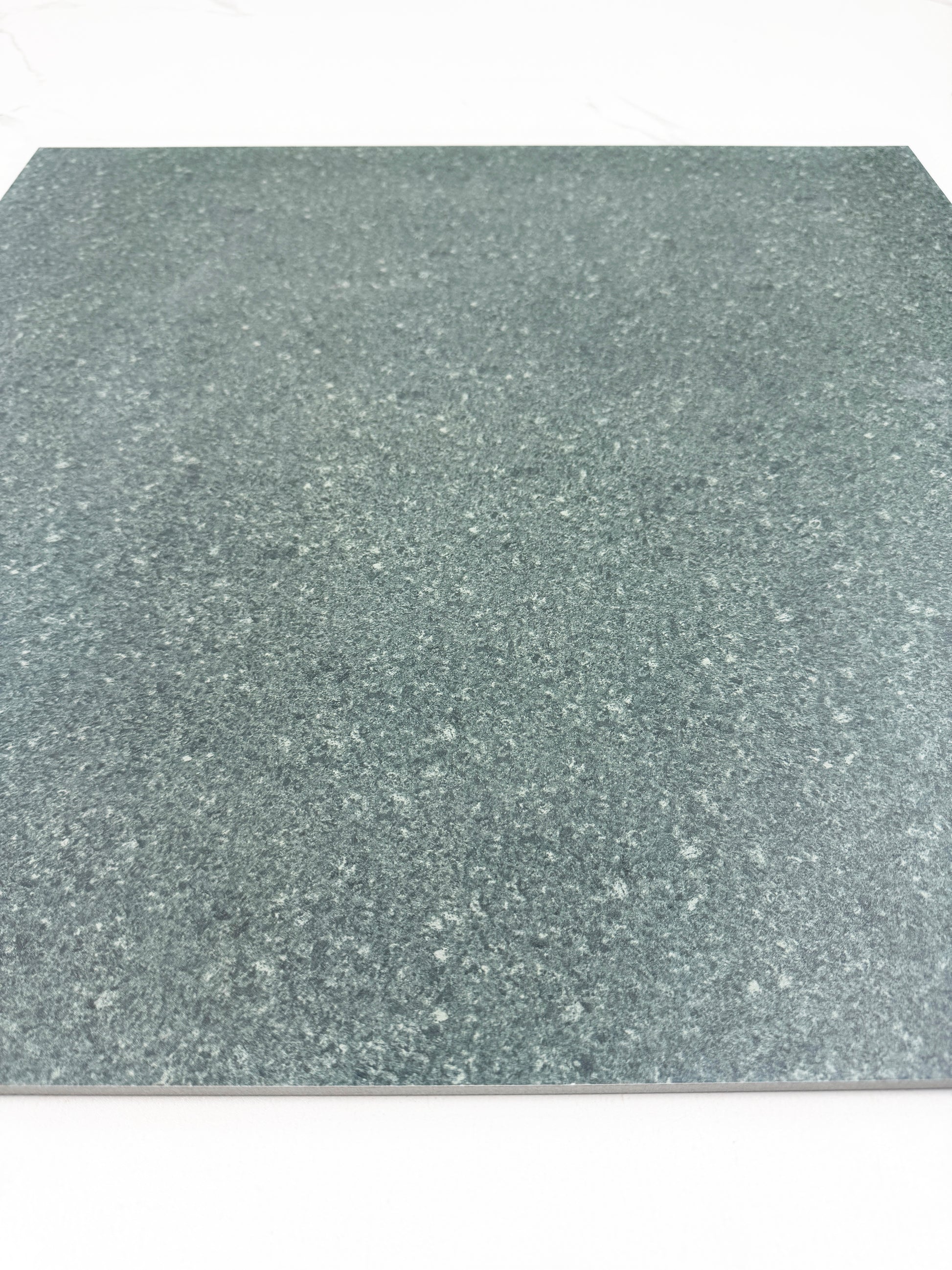 green sukabumi with a speckled pattern on a white background